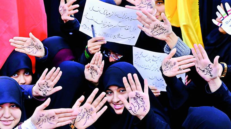 Iranian girls take part in a demonstration outside the former US embassy in the Iranian capital Tehran on Sunday marking the anniversary of its storming by student protesters that triggered a hostage crisis in 1979. Farsi writing on their palms praising the supreme leader Ayatollah Ali Khamenei. (AFP)
