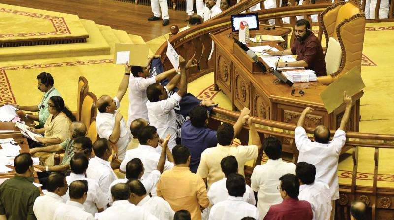 Opposition MLAs gather near Speakers podium in the Assembly on Thursday. (Photo: A.V. MUZAFAR)