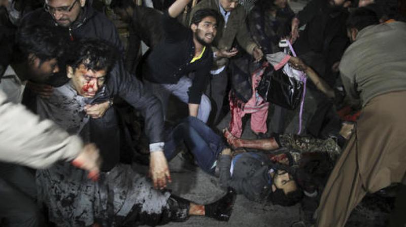 Pakistani volunteers help injured people to ambulances following a deadly bombing, in Lahore, Pakistan. (Photo: AP)