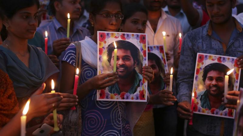 Activist of a Dalit organization participate in a candle light vigil holding photographs of Indian student Rohith Vemula in Hyderabad. (Photo: AP)