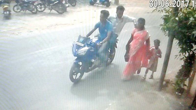 A CCTV video grab shows the bike-borne duo snatching a womans chain on Friday.