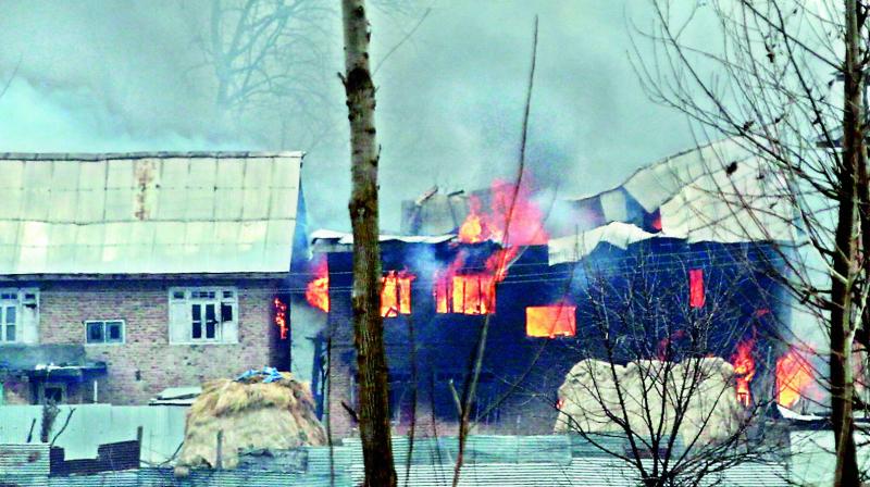 Flames and smoke rise from the house where two terrorists allegedly involved in the CRPF attack were said to be hiding, during an encounter with security forces, in Pinglena area of Pulwama district on Monday.  (h.u. naqash)