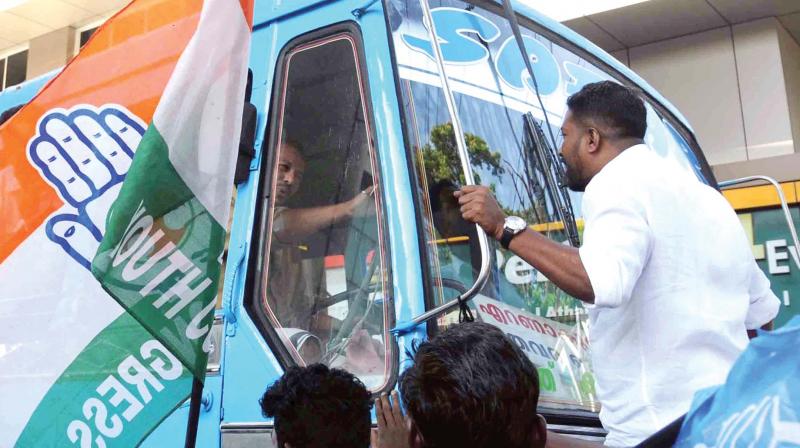 Youth Congress workers block a private bus and is about to smash its windshield at MG Road, Kochi on Monday as part of the flash hartal following the murder of two Congress workers at Kasargode. (ARUN CHANDRABOSE)