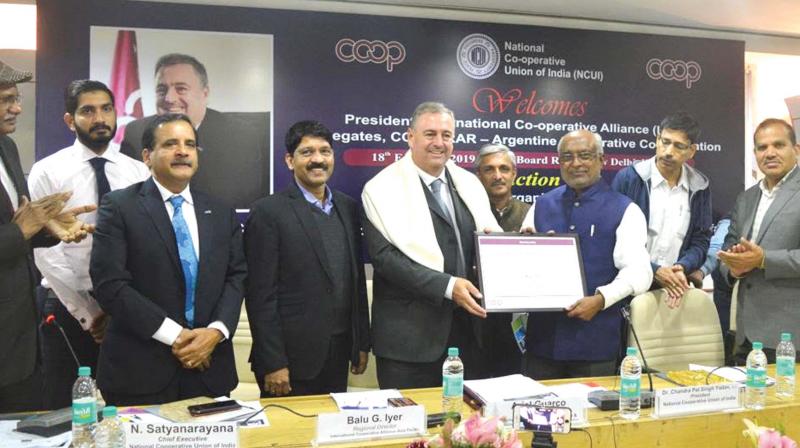International Co-operative Alliance(ICA) president  Ariel Guarco gives the ICA membership to Uralungal Labour Contract Co-operative Society chairman Remeshan Paleri in New Delhi on Monday .