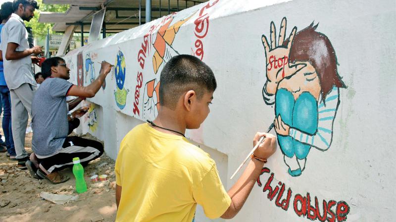 Udhavidathan Piranthom members paint  awareness paintings on the compound wall of Bala Gurukulam School in Villivakkam, on Sunday. (Photo: DC)