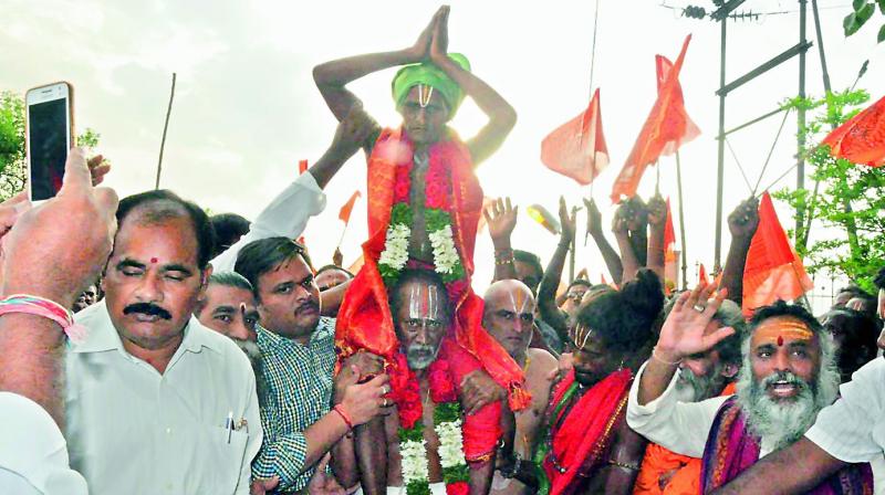 Ranganathaswamy temple main priest Jagannadha Acharyulu is seen carrying Dalit devotee from MahaRajaGopuram in Nellore city on Thursday.
