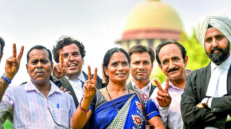 Dec. 16 gangrape victims parents show victory sign after the Supreme Courts verdict in New Delhi on Monday. (Photo: PTI)
