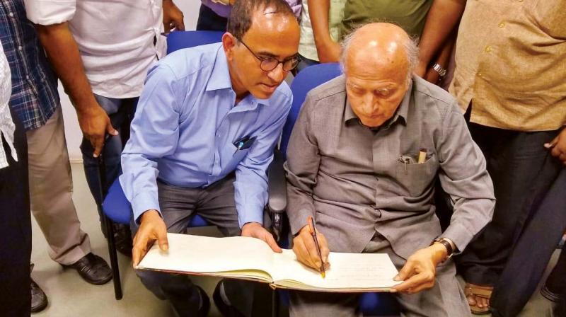 Prof. M.S. Swaminathan signs a guestbook at St. Josephs College in Bengaluru on Monday 	DC