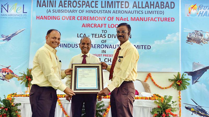 R. K. Mishra (left) presenting the Certificate of Conformity of aircraft and helicopter looms to M S Velpari (right) in the presence of V M Chamola at the function