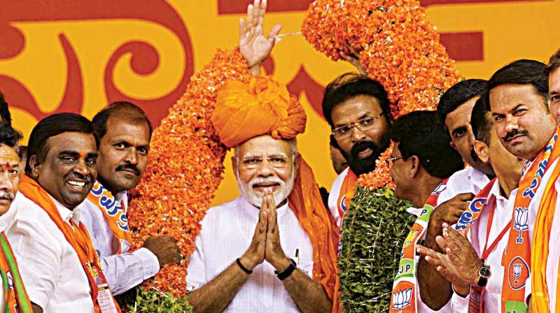 PM Narendra Modi being felicitated by BJP candidiates B Sriramulu and Gali Somashekhara Reddy at a rally in Ballari on Thursday. (Photo:KPN)