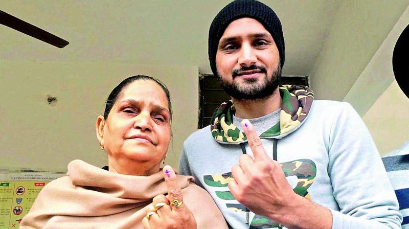 Cricketer Harbhajan Singh and his mother show indelible ink marked on their fingers after casting their votes at a polling station in Jalandhar, Punjab on Saturday. 	(Photo: PTI)