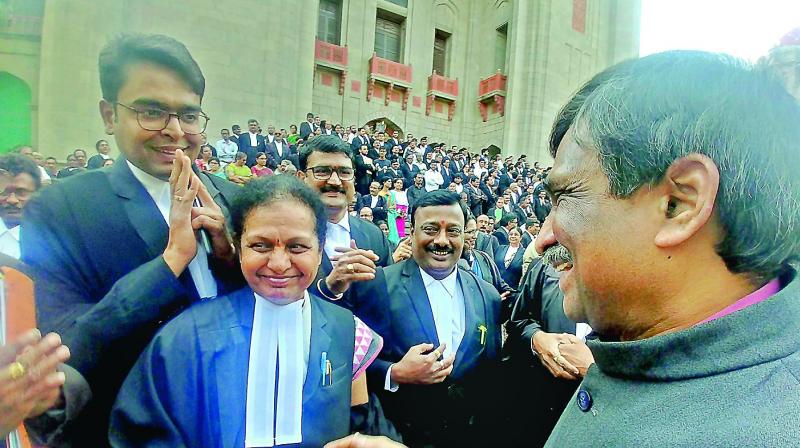 Justice A.V. Sesha Sai, who has been shifted to Andhra Pradesh, shakes hands with TS government pleader Vani Reddy on the last day of the combined High Court in Hyderabad on Tuesday. (Photo: P. Surendra)