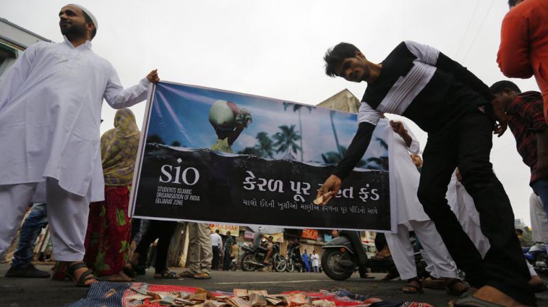 Indian volunteers hold a banner and collect donations for the people affected by floods in the Indian southern state of Kerala after Eid al-Adha prayers at Jama Masjid in Ahmadabad. (Photo: AP)