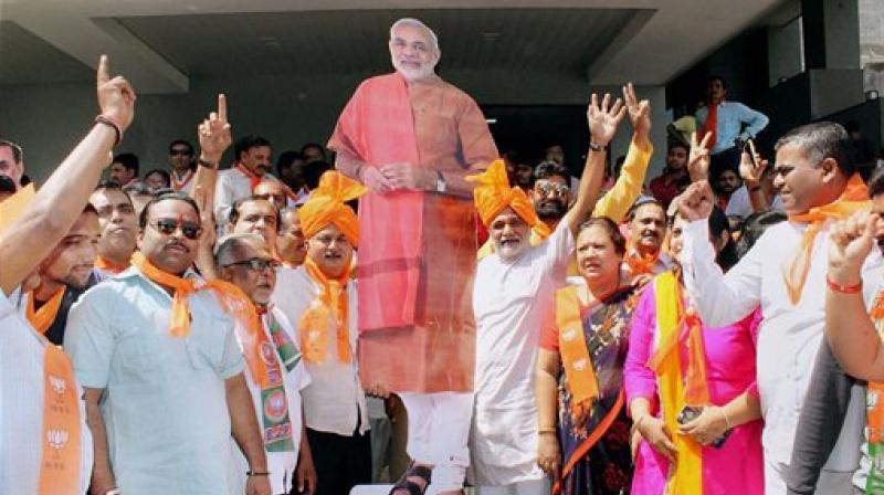 BJP supporters celebrating the partys victory in UP and Uttarakhand Assembly polls in Surat. (Photo: PTI)