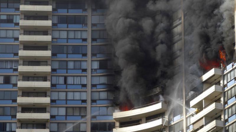 Smoke billows from the upper floors of the Marco Polo apartment complex in Honolulu (Photo: AP)