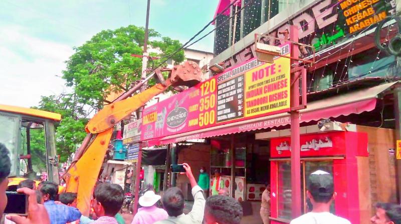 A GHMC team razes an illegal structure on a footpath on Sunday.