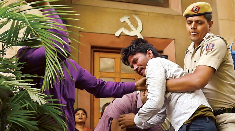 Police take away a Hindu Sena activist who was trying to disrupt CPI(M) general secretary Sitaram Yechurys press briefing at the party headquarters in New Delhi on Wednesday. (Photo: PTI)