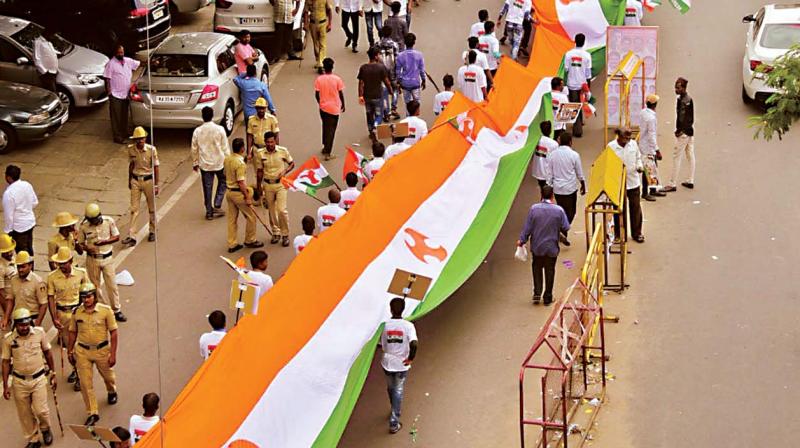 Congress workers display a huge flag during the installation of Youth Congress office-bearers at the KPCC office in Bengaluru on Wednesday.