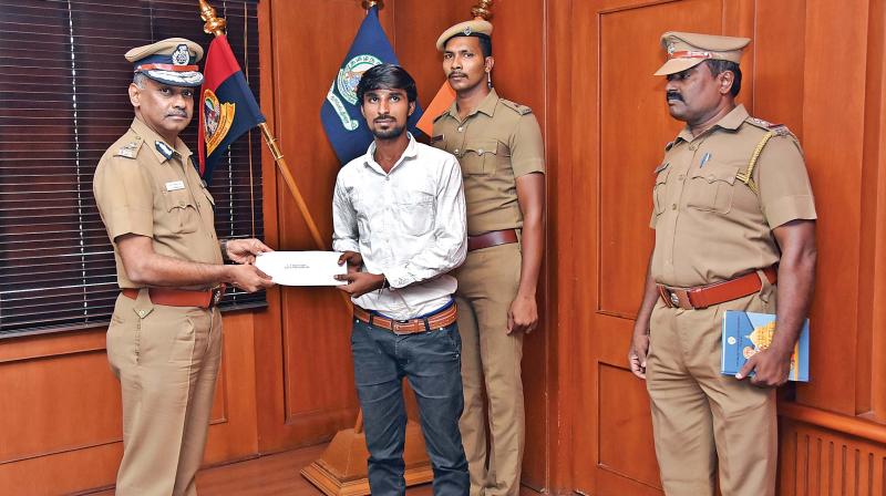 City police commissioner A.K. Viswanathan hands over reward to Friend of Police Balamurugan for catching armed robbers in Aminjikarai, on Friday.(Photo:DC)