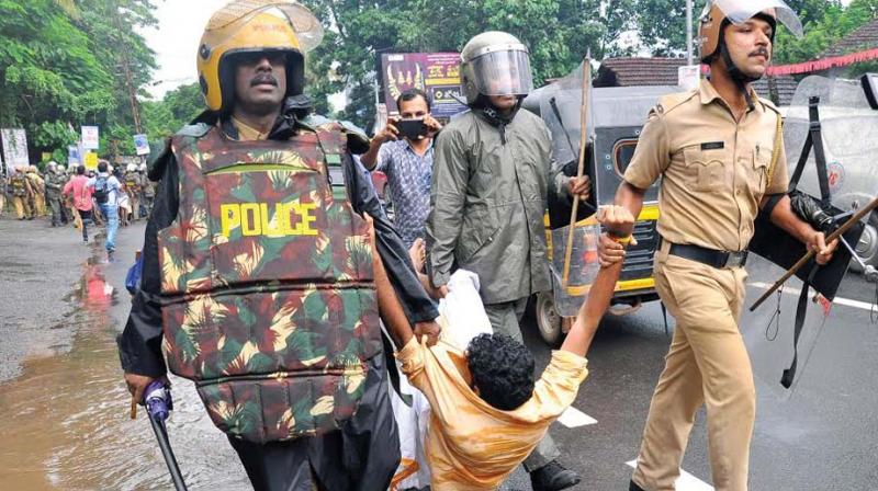 Police remove an agitator when the ABVP protest march against fee hike in self-financing medical colleges in the state turned violent  at Collectorate, Kozhikode on Friday. (Photo: DC)