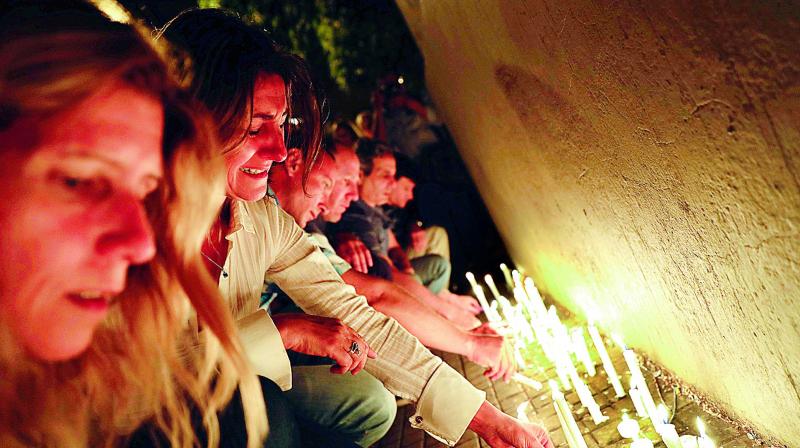 Locals place candles outside the Polytechnic School in Rosario, Argentina (Photo: AP)