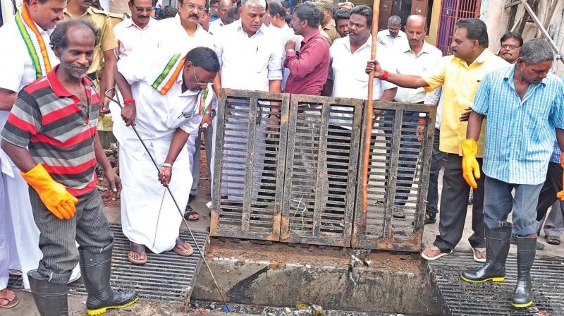 Chief Minister V. Narayanasamy checks a stormwater drain while visiting rain affected areas in Puducherry on Thursday. (Photo: DC)