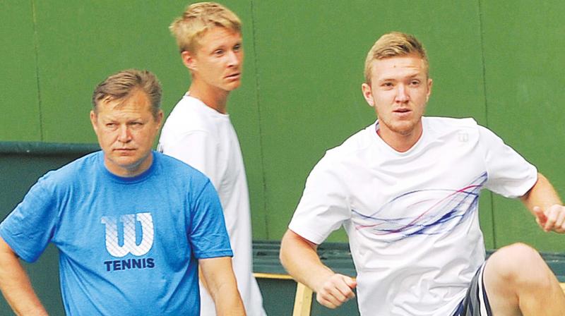 Uzbekistans Temur Ismailov (right) warms up  alongside team captain Petr Lebed and Sanjar Fayziev at the KSLTA courts in Bengaluru on Tuesday. (Photo: DC)