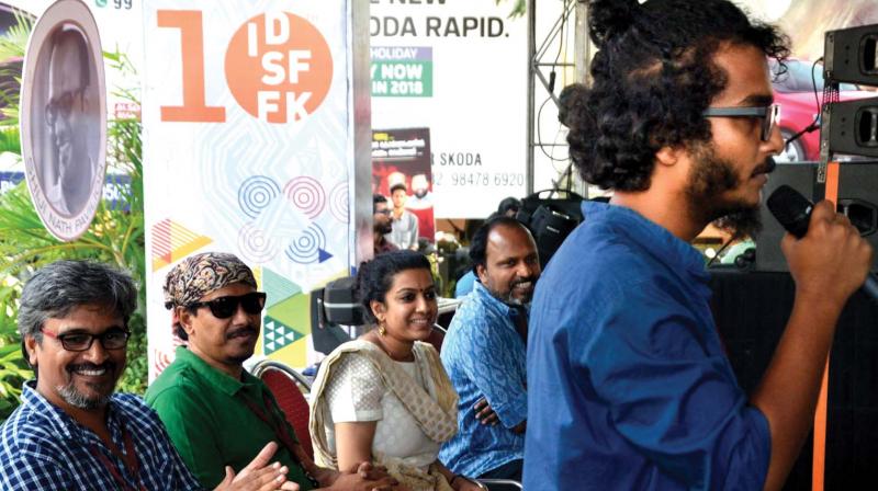 Ajayan Adat, sound designer, speaks at the impromptu protest meeting at the ISDFFK in Thiruvananthapuram on Sunday. Director Amudan, Bengali director Supriyo Sen, Priya Thoovassery, and K.M. Kamal looks on. (Photo: DC)