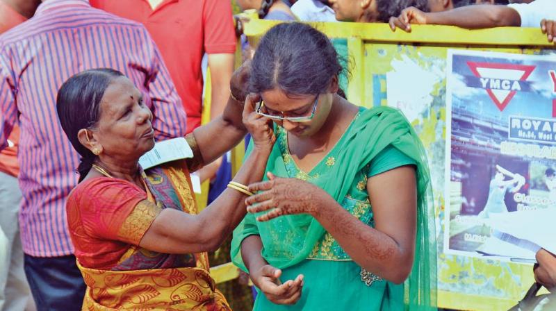 A student is made to remove her jewellery before entering the exam hall. (Photo: DC)
