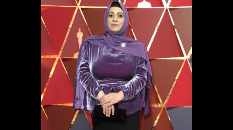 Syrian refugee Hala Kamil, the subject of the Oscar-nominated short documentary â€œWatani: My Homelandâ€attended the Academy awards in a purple and black two-piece velvet gown with a matching purple hijab by Lady Gagas stylist Brandon Maxwell. (Photo: AP)