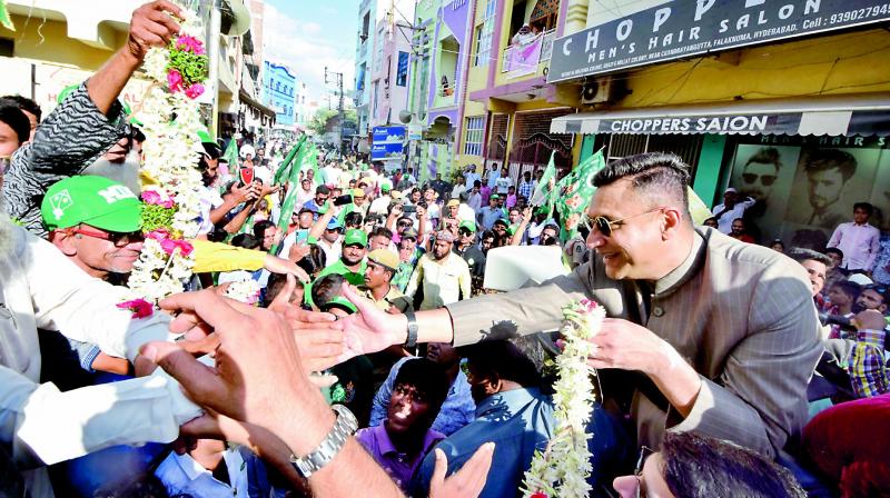 MIM legislator Akbaruddin Owaisi reaches out to crowds after filing his nomination papers on Saturday. (Image DC)