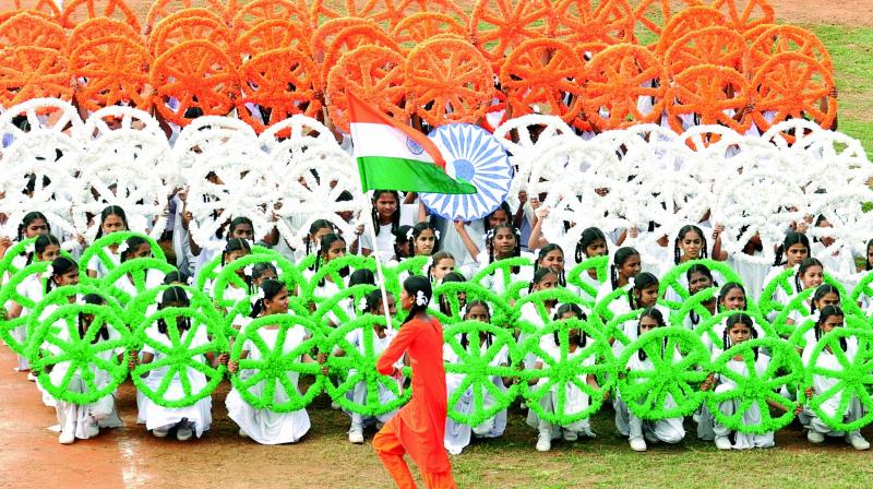 Children perform a dance and hold up the Tri-colour as a part of Republic Day celebrations organised by the district administration at Police Barracks stadium in Visakhapatnam on Friday. (Photo: DC)