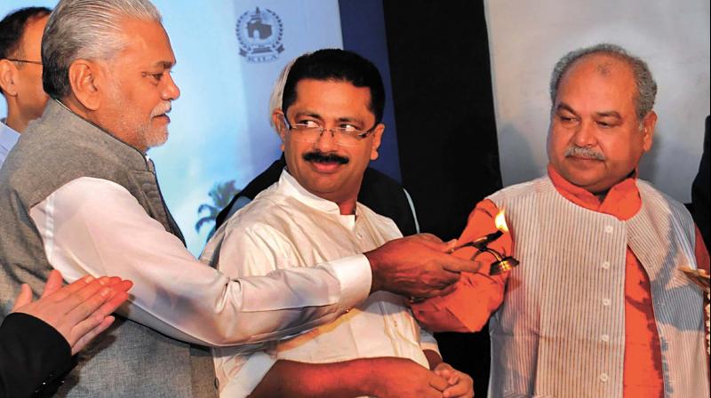 State local administration minister K.T. Jaleel has a surprised look on his face as he watches Union Minister Naendra Singh Tomar handing the lighter over to Minister for State Parshottam Rupala past him to light the ceremonial lamp during the inauguration of the Participatory Local Budgeting project of BRICS nations in Kochi on Thursday.	(Photo:  ARUNCHANDRA BOSE)