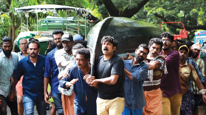 A group of fisher folks carrying a country boat for rescue operations at Paravur on Sunday.  (Photo:DC FILE)