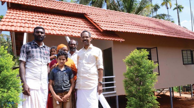 Minister for labour and excise T.P. Ramakrishnan in front of the model house along with Kalathingal Pathumma and family at 4th Mile, Pozhuthana, Wayanad on Thursday.