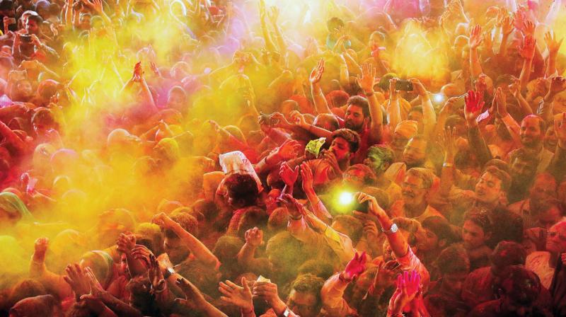 Devotees play with gulal on the occasion of Holi at Govind Dev Ji temple in Jaipur on Thursday. (Photo: PTI)