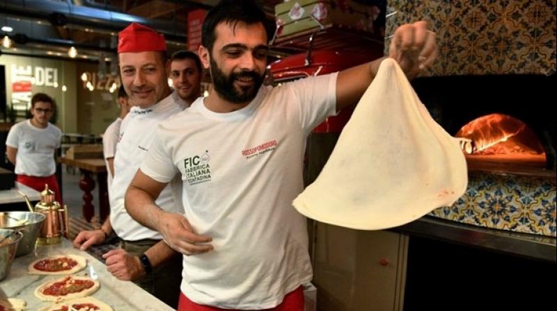 Pizza bakers prepare traditional pizza margherita during a press tour at FICO Eataly World agri-food park in Bologna. (Photo: AFP)