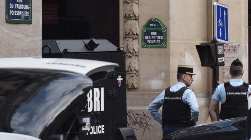 Gendarmes stand next to a Police BRI intervention brigade vehicle on June 12, 2018 in central Paris near the site where an armed man had taken hostages. (Photo: AFP)