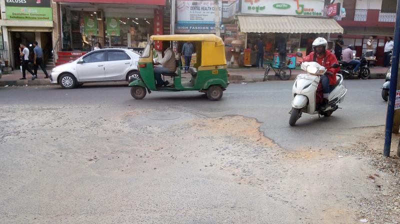 A two-wheeler rider tries to manoeuvre around big potholes in Koramangala 6th Block.	(DC)