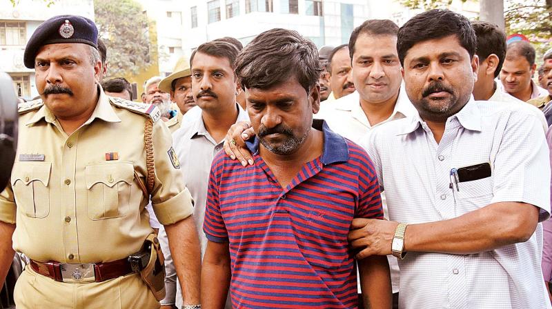 ATM cash van driver Dominic Selvaraj Roy being escorted by the police, in Bengaluru on Tuesday (Photo:DC)