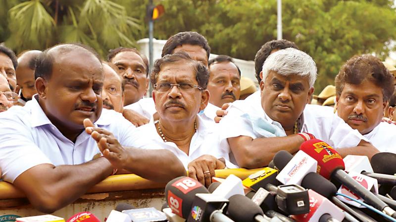 JD(S) State president H.D. Kumarswamy (left) and KPCC President Dr G. Parameshwar (centre) address the media with JD(S) and Congress leaders after meeting Governor Vajubhai Vala  at Raj Bhavan, in Bengaluru on Wednesday  (Image: DC)