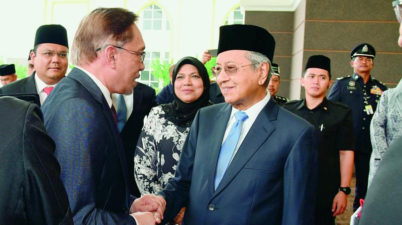 Anwar Ibrahim (left) greets Malaysias Prime Minister Mahathir Mohamad at the National Palace.  (Image: AP)