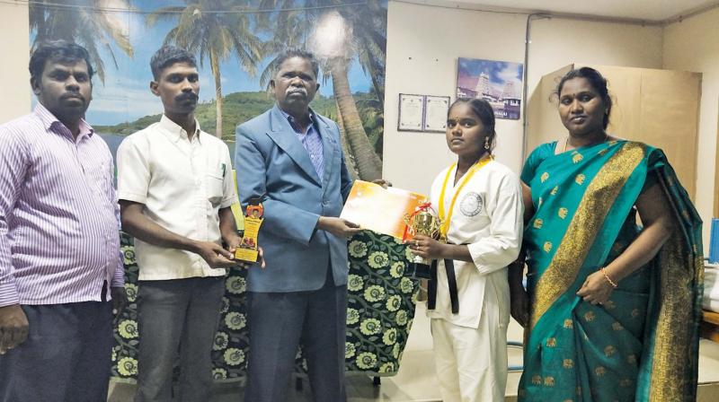Palaniswamy, principal of Government arts college Ariyalur, greets Suganthi for her achievement in the All India Martial Arts championship-2018 kickboxing event held at Puducherry.	DC