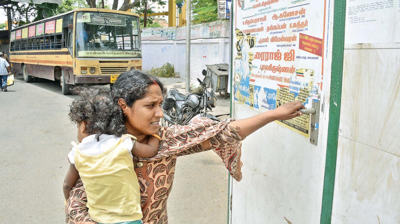 A lactating mother tries pulling open a locked feeding room at Saidapet bus terminus in vain.