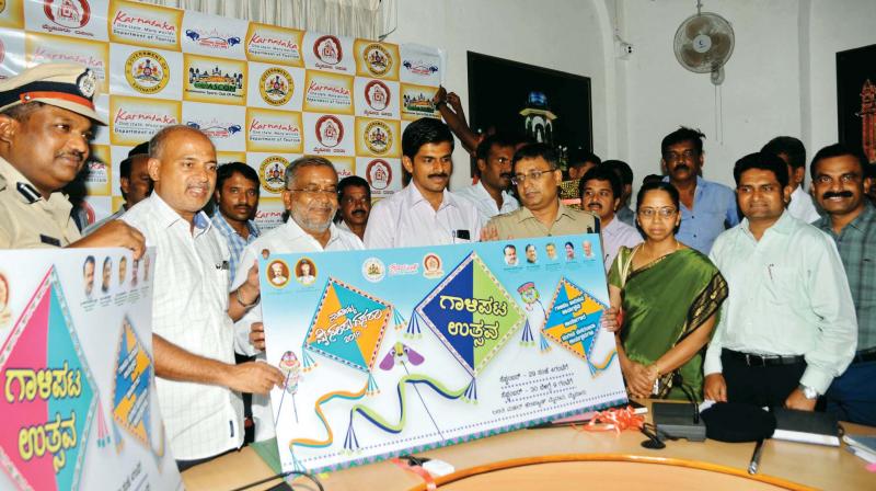 Minister G.T. Devegowda (centre) releases the posters of kite festival during Dasara celebrations, in Mysuru on Wednesday. (Photo:KPN)