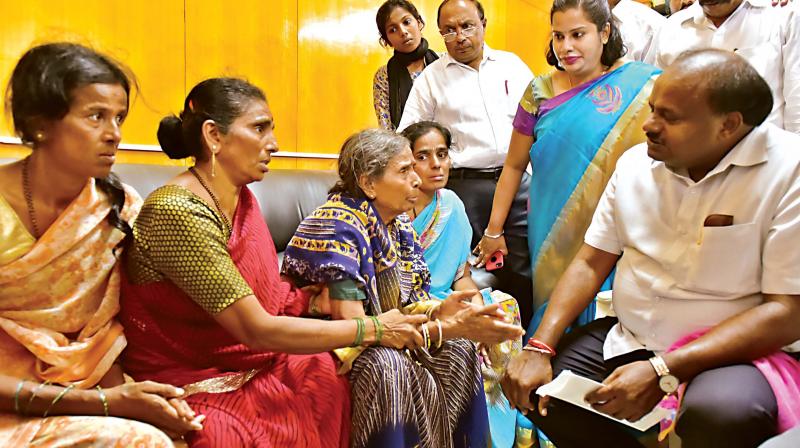 Chief Minister H.D. Kumaraswamy hands over a cheque for Rs 2 lakh to the family of Nandish who committed suicide along with his wife and two children in Pandavapura in Mandya district (Photo:DC)