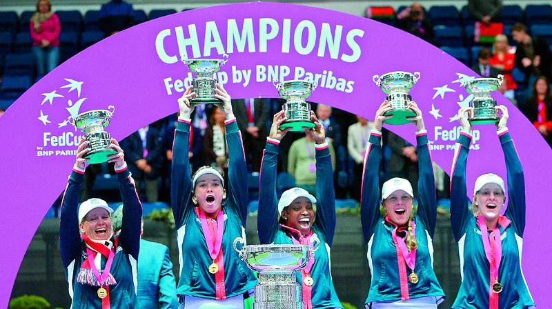 US team celebrate with their trophies after winning the Fed Cup final against Belarus in Minsk on Sunday. (Photo: AFP)