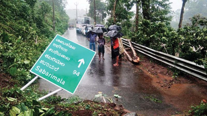 People gather near a landslide site at Chappath near Upputhara in Idukki district on Sunday following heavy rains in the state. Traffic was partly affected in many areas on account of the landslide. 	(Photo: BY ARRANGEMENT)