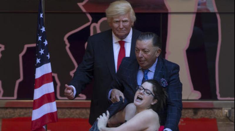 A woman makes a semi-naked protest during the inauguration of a figure of U.S. President-elect Donald Trump at the Wax museum in Madrid, Spain. (Photo: AP)