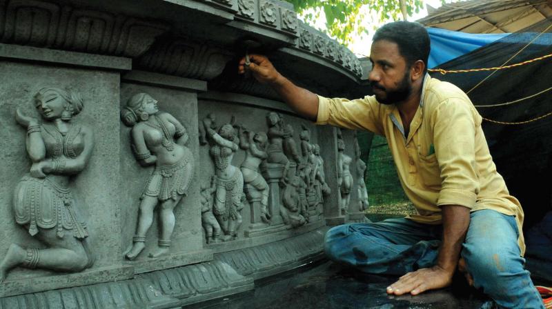 Artist Shaji Poilkavu gives the final touches to the cement relief. (Photo: DC)